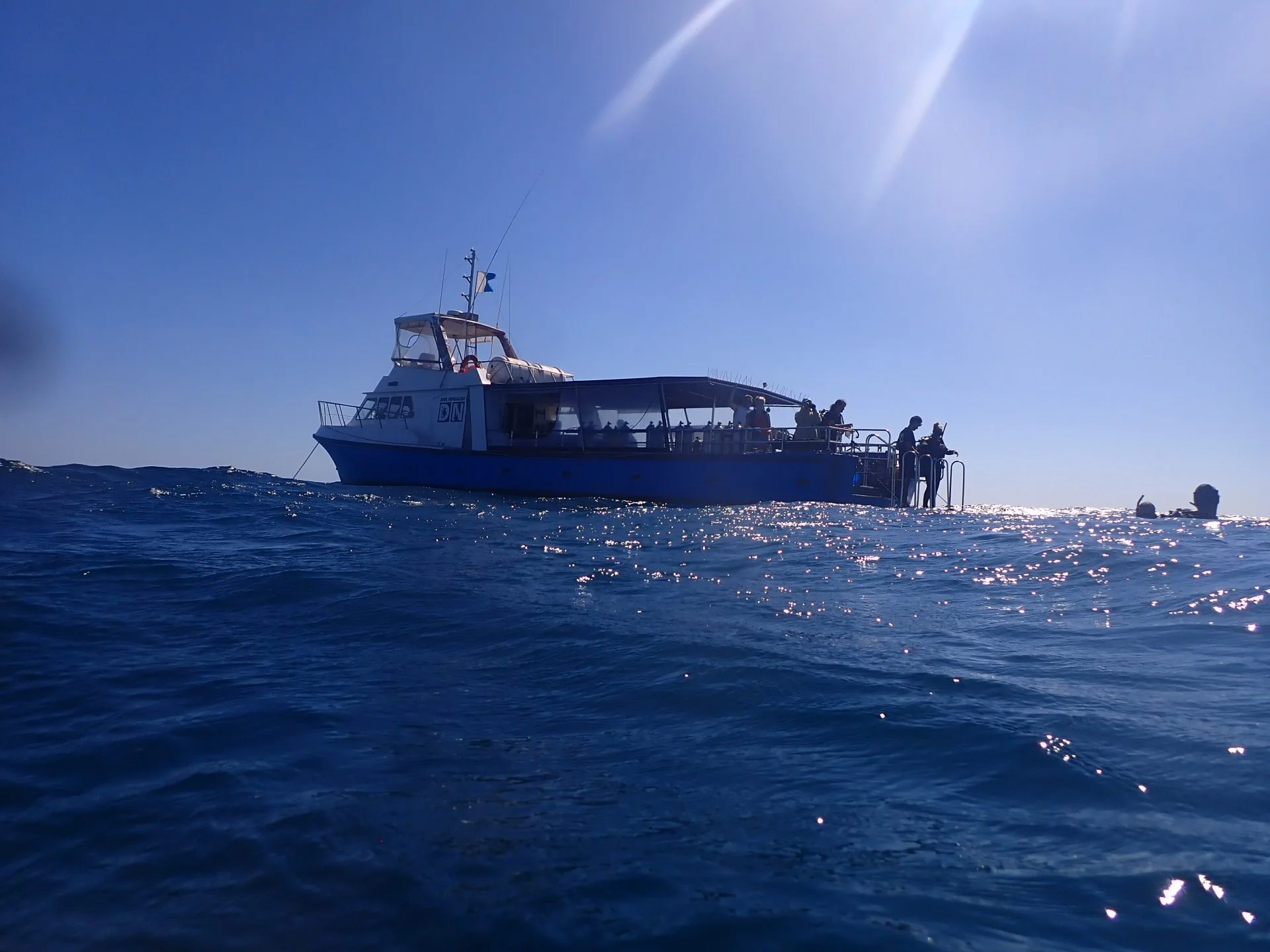 Dive Ningaloo boat on the water with divers at the stern