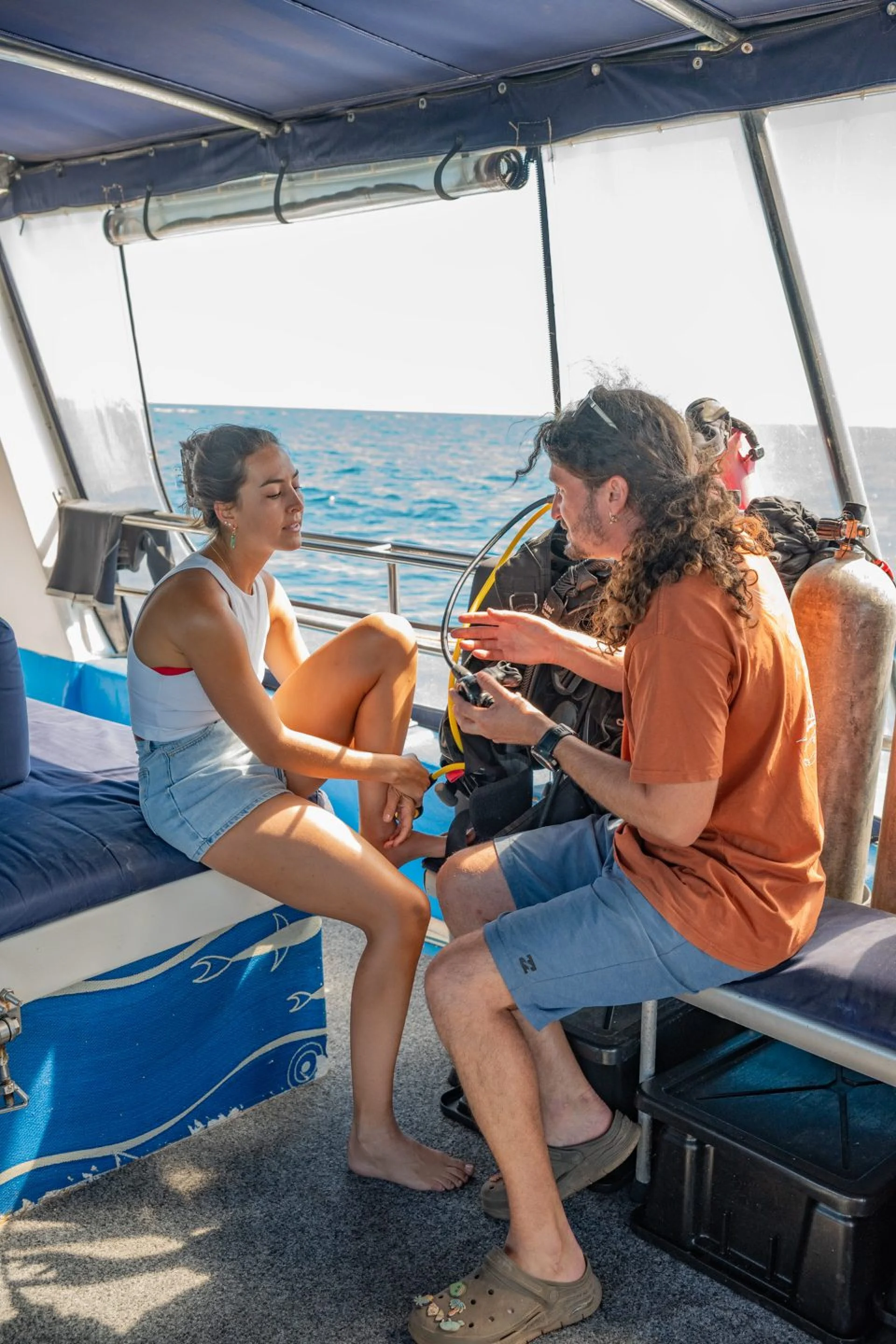 Crew member helping a guest with her scuba gear