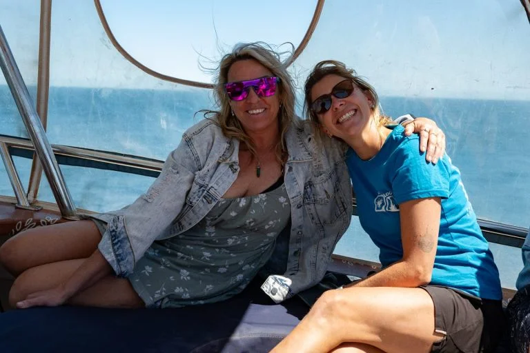 Two friends smiling together on the boat